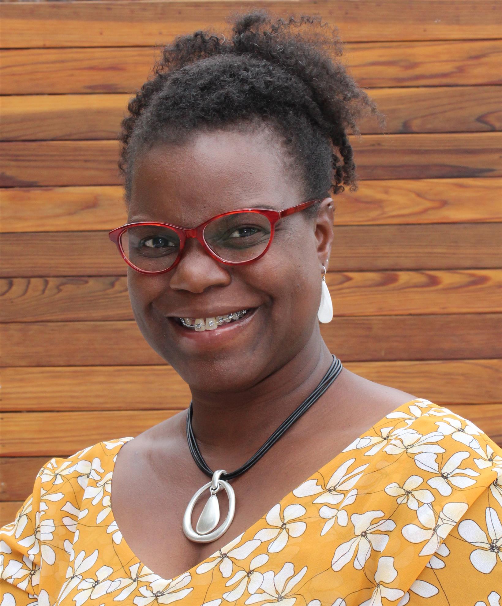 Headshot of Dr. Abigail Joseph, a black woman with her hair pulled back, red framed glasses and a bright yellow blouse.