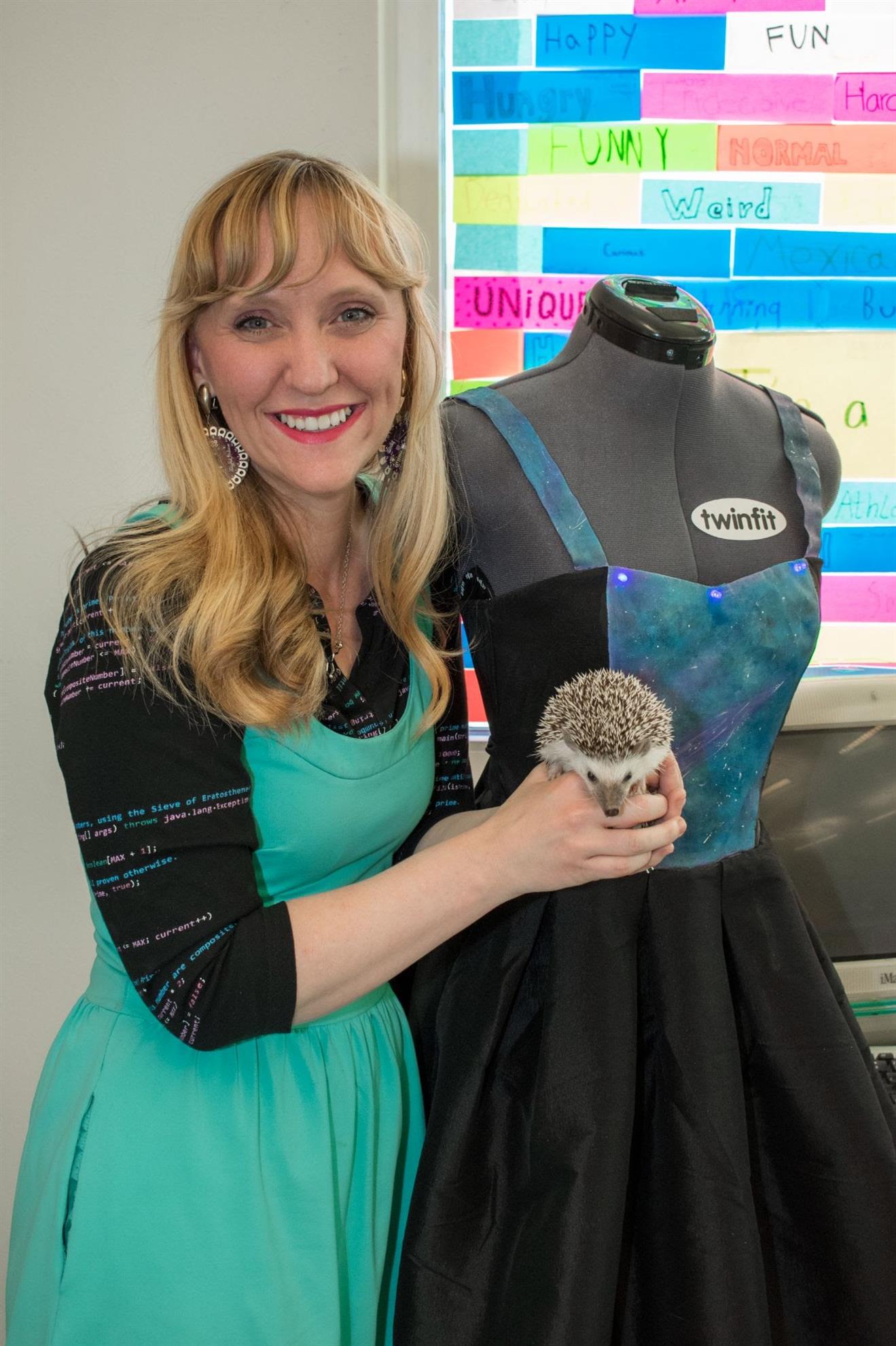 Melody holding a hedgehog and posing next to a mannequin